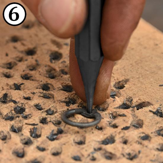 Punching a hole into a ring for for making riveted chainmail rings.